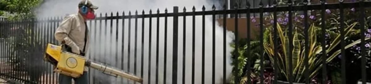 Mosquito control technician fogging a yard perimeter for mosquito reduction in Oklahoma City, OK